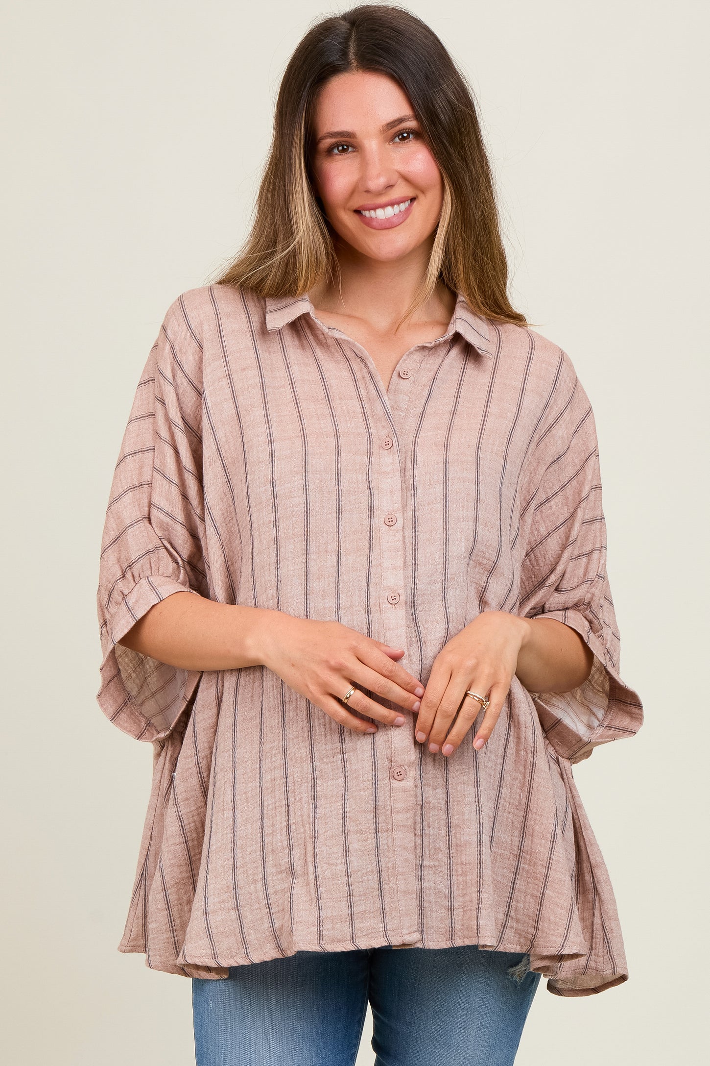 woman wearing a light pink striped maternity top with button details and a relaxed fit