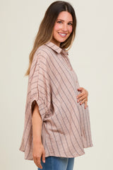 woman wearing a light pink striped maternity top with button details and a visible baby bump