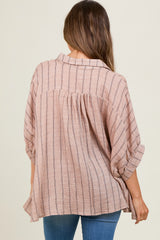 woman wearing a blush striped maternity top with rolled sleeves, showing her back and a flowing fit over her baby bump