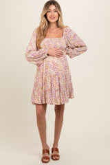 woman wearing a floral print maternity dress with puff sleeves and a baby bump
