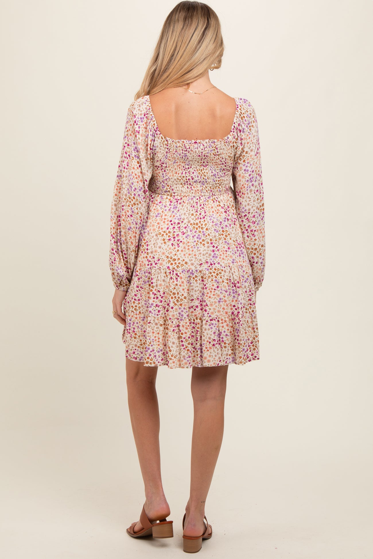 woman wearing a floral print short sleeve maternity dress with a smocked bodice and flared skirt