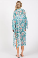 woman wearing a teal floral kimono with wide sleeves and side slits, seen from the back