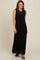 woman wearing a black ribbed maxi dress with a sheer striped neckline and side slits