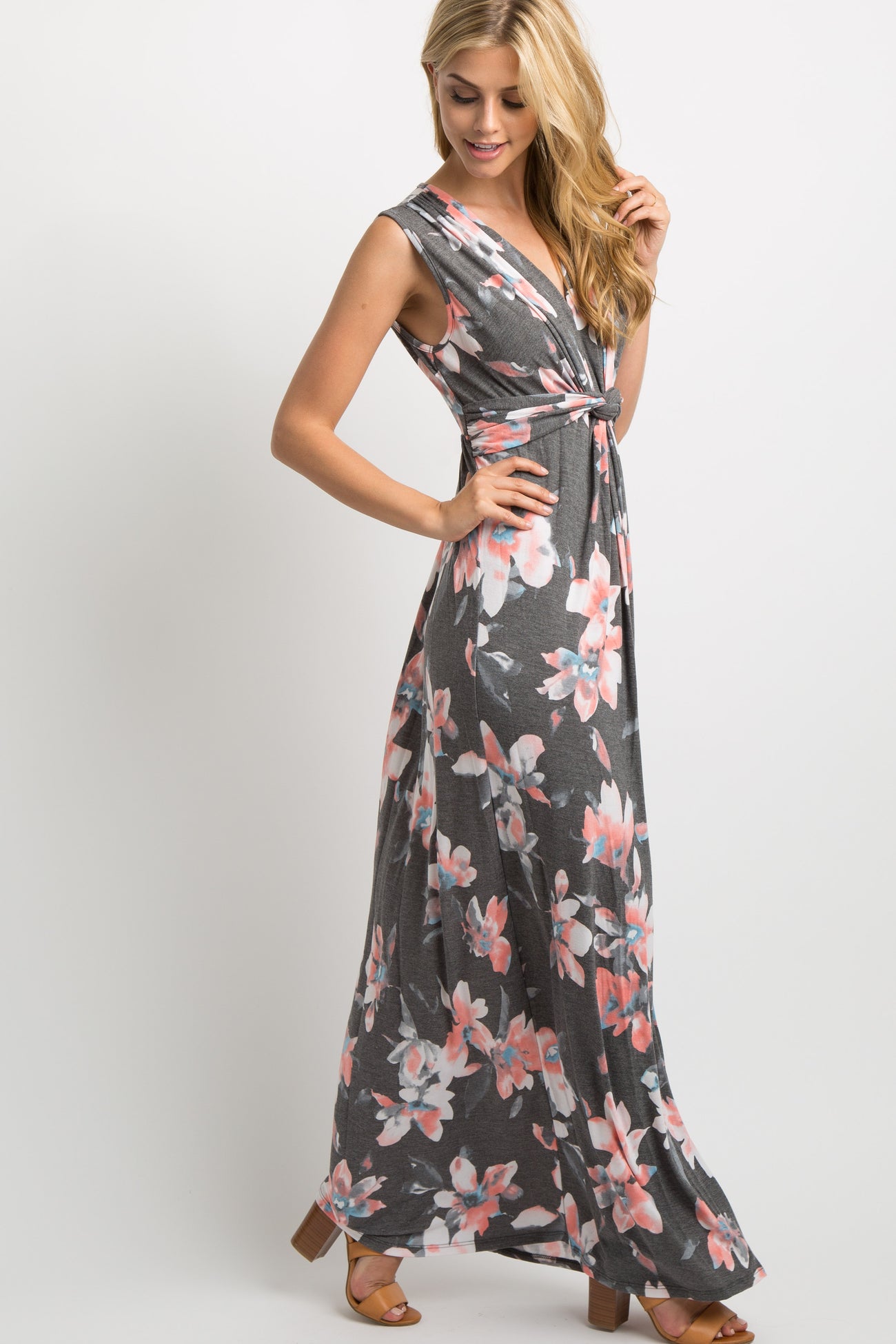 pregnant woman wearing a charcoal floral sleeveless maternity maxi dress against a white background