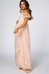 pregnant woman in a light pink floral lace maternity maxi dress with off-the-shoulder ruffle sleeves