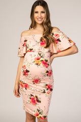 woman wearing a pink floral off-the-shoulder maternity dress with a ruffled neckline