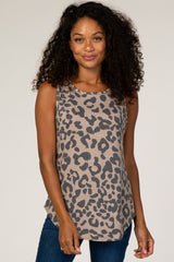 woman with curly hair wearing a tan and black leopard print sleeveless tank top and blue jeans