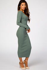 woman wearing a fitted green ribbed long sleeve midi dress and nude heels