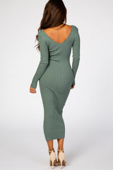 woman wearing a green ribbed long sleeve bodycon dress with a deep v-back and fitted silhouette