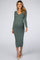 woman wearing a green ribbed maternity midi dress with a v-neck and long sleeves, showcasing her baby bump