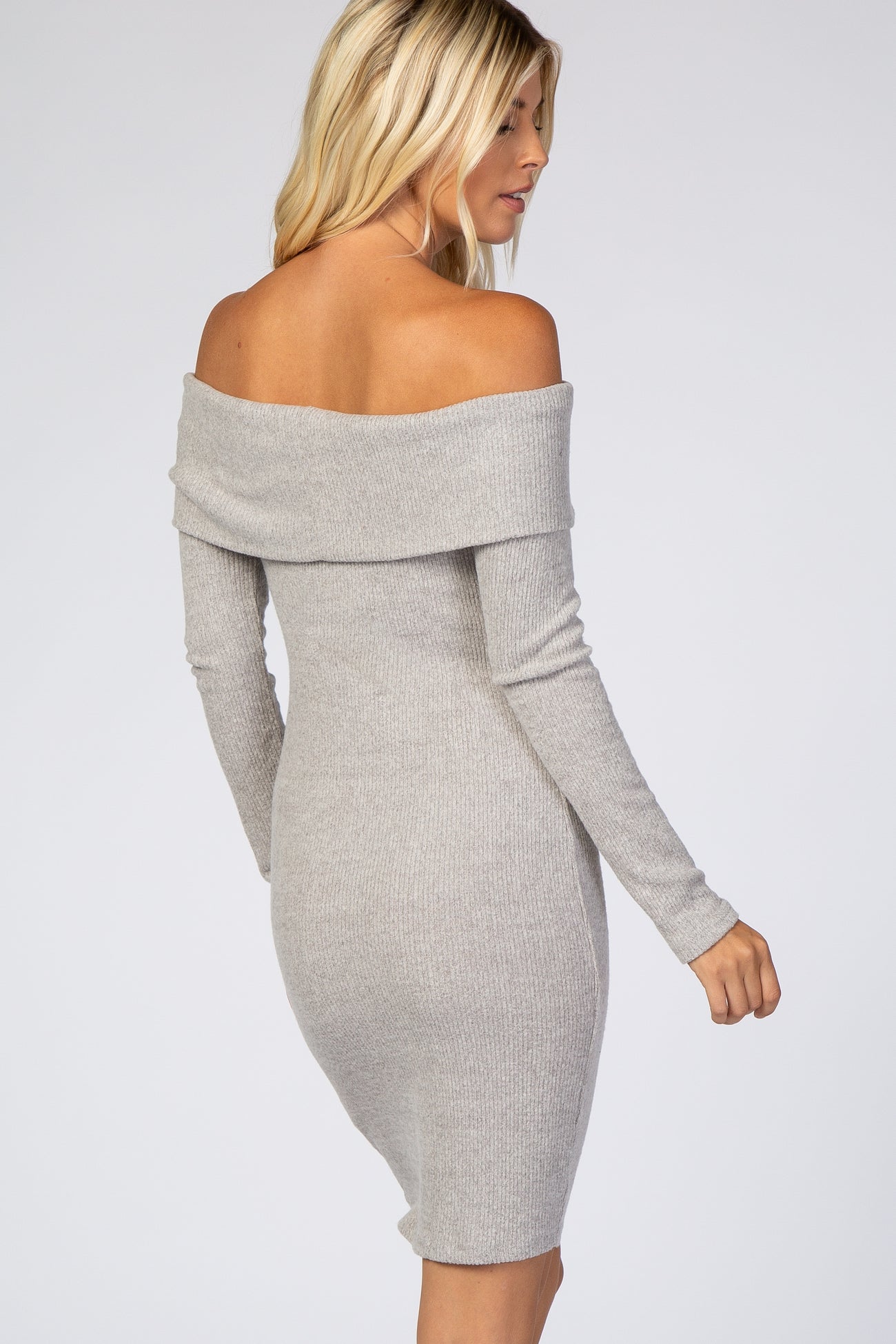 woman wearing a light grey off-the-shoulder ribbed dress with long sleeves
