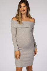woman wearing a light gray off-shoulder maternity dress that fits over her baby bump