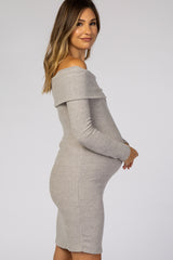 woman wearing a grey ribbed off-the-shoulder maternity dress and holding her baby bump