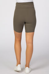 Back view of person wearing olive green ribbed maternity biker shorts and white sneakers