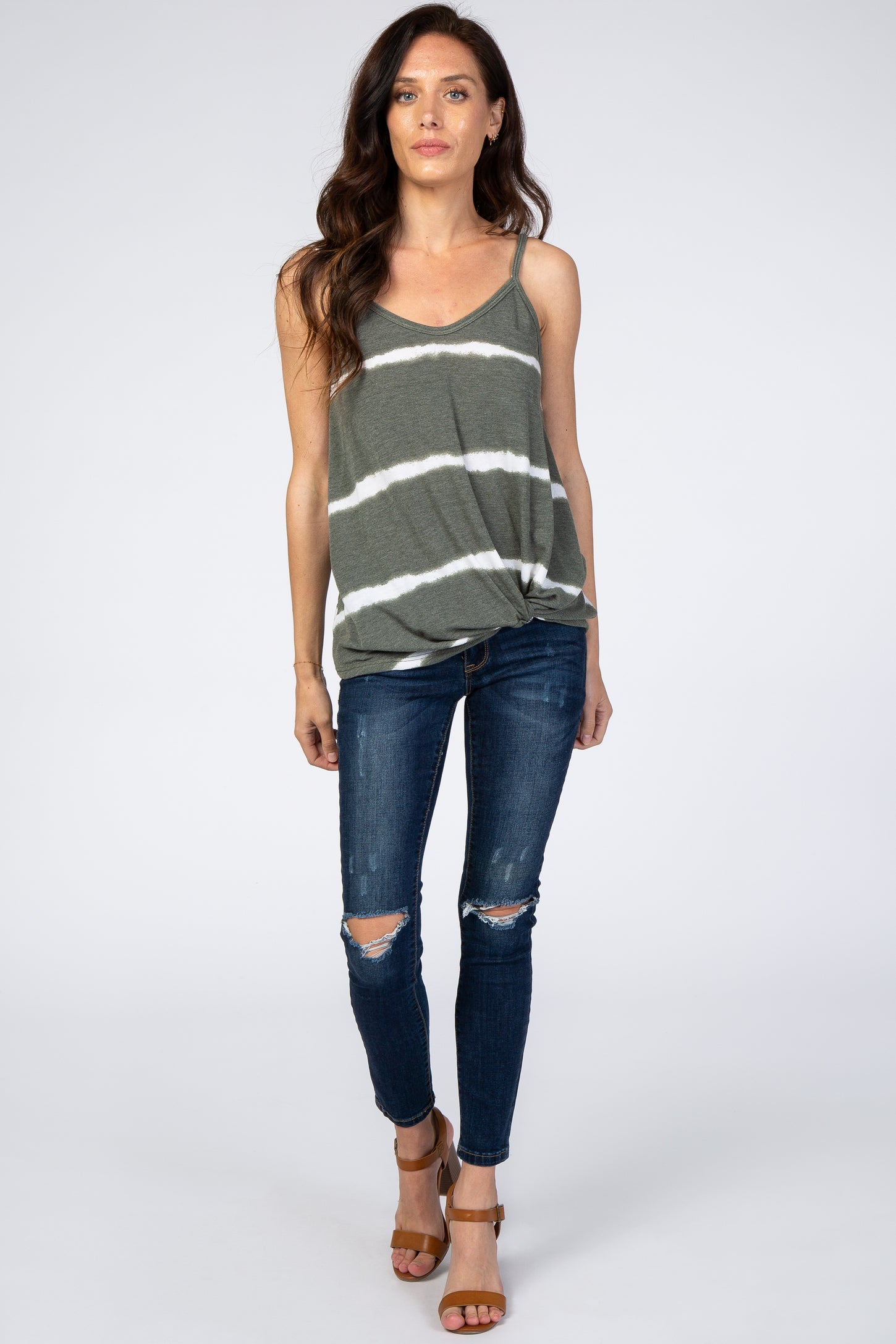 woman wearing olive green striped maternity tank top and distressed skinny jeans with brown sandals