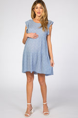 pregnant woman wearing a light blue floral maternity dress with ruffle sleeves and white heels