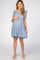 pregnant woman wearing a light blue floral maternity dress with ruffle sleeves and white heels