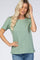 blonde woman wearing a sage green short sleeve crew neck t-shirt and blue jeans