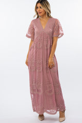 woman wearing a mauve floral lace maxi dress with short flutter sleeves and a v-neckline