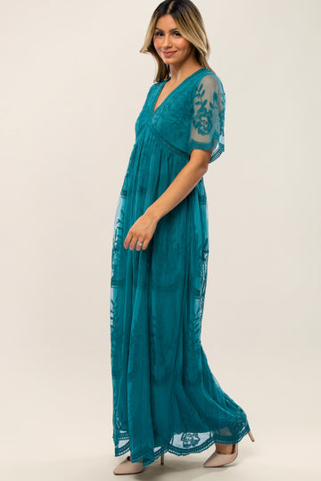 woman wearing a teal maxidress with sheer embroidered sleeves and a v-neckline