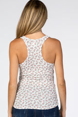 Back view of a woman wearing a white floral print racerback tank top and blue jeans