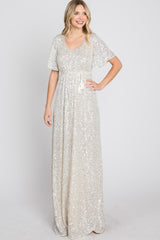 woman wearing a glamorous silver sequin maxi dress with short sleeves and a tie waist detail