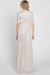 woman wearing a shimmer silver sequin long evening dress with short sleeves and a fitted waist, seen from the back