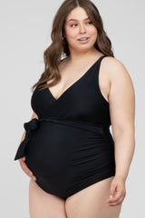 pregnant woman wearing a black one-piece maternity swimsuit with a side tie and v-neckline