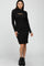woman wearing a black long sleeve ribbed knit dress with a cutout neckline and black ankle boots