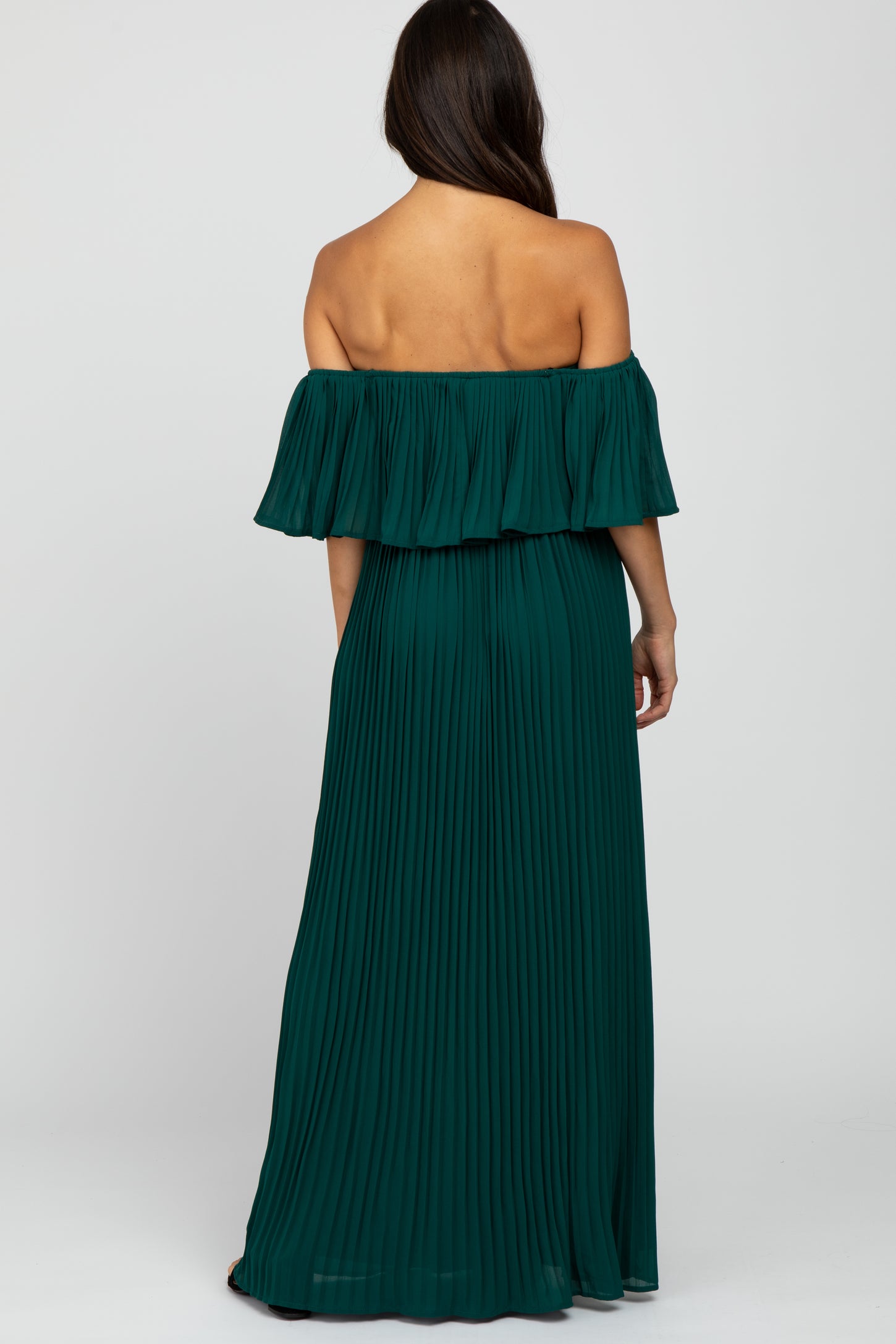 Back view of a woman wearing a forest green off-the-shoulder pleated maxi dress
