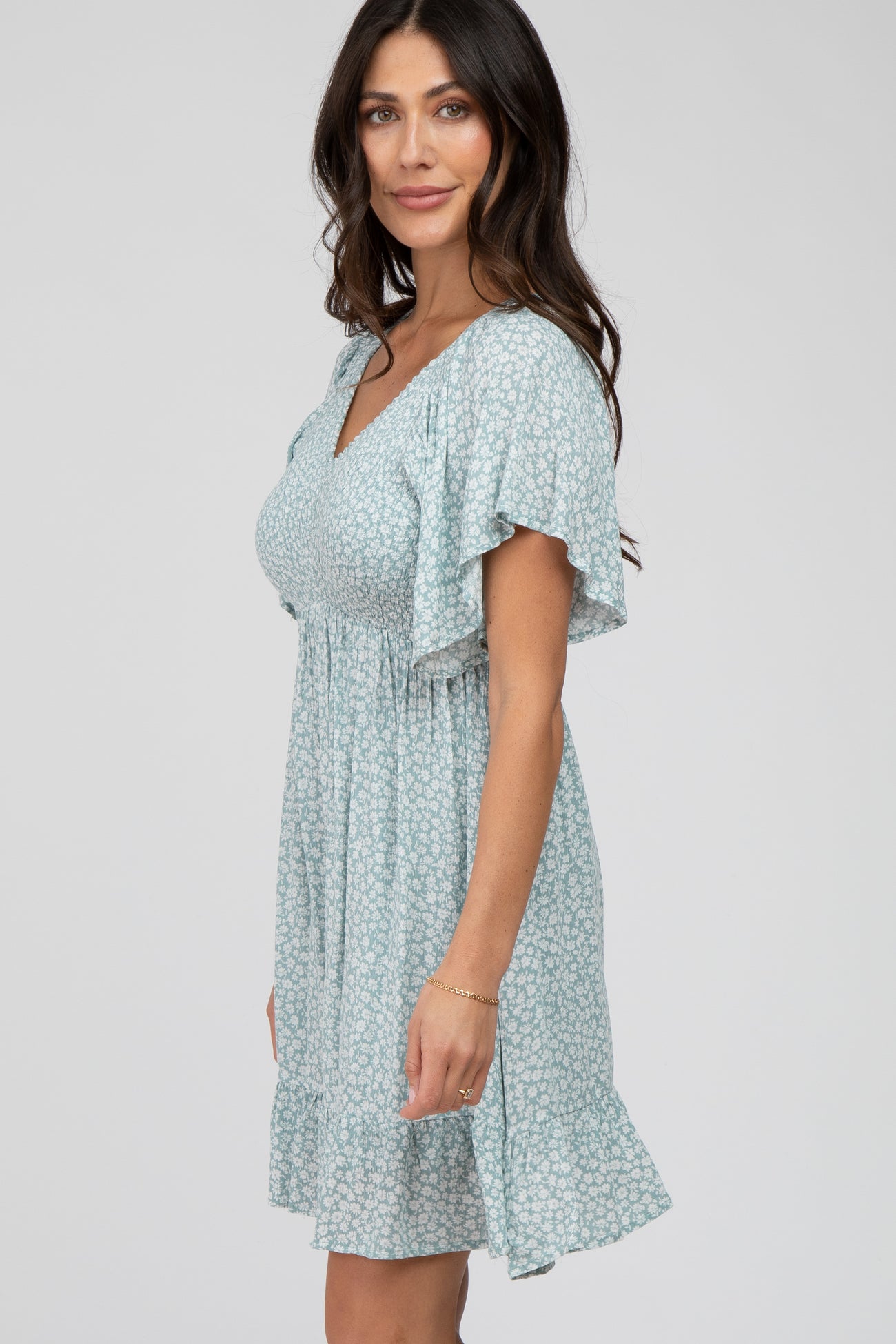 woman wearing a light blue floral print maternity dress with flutter sleeves and smocked bodice