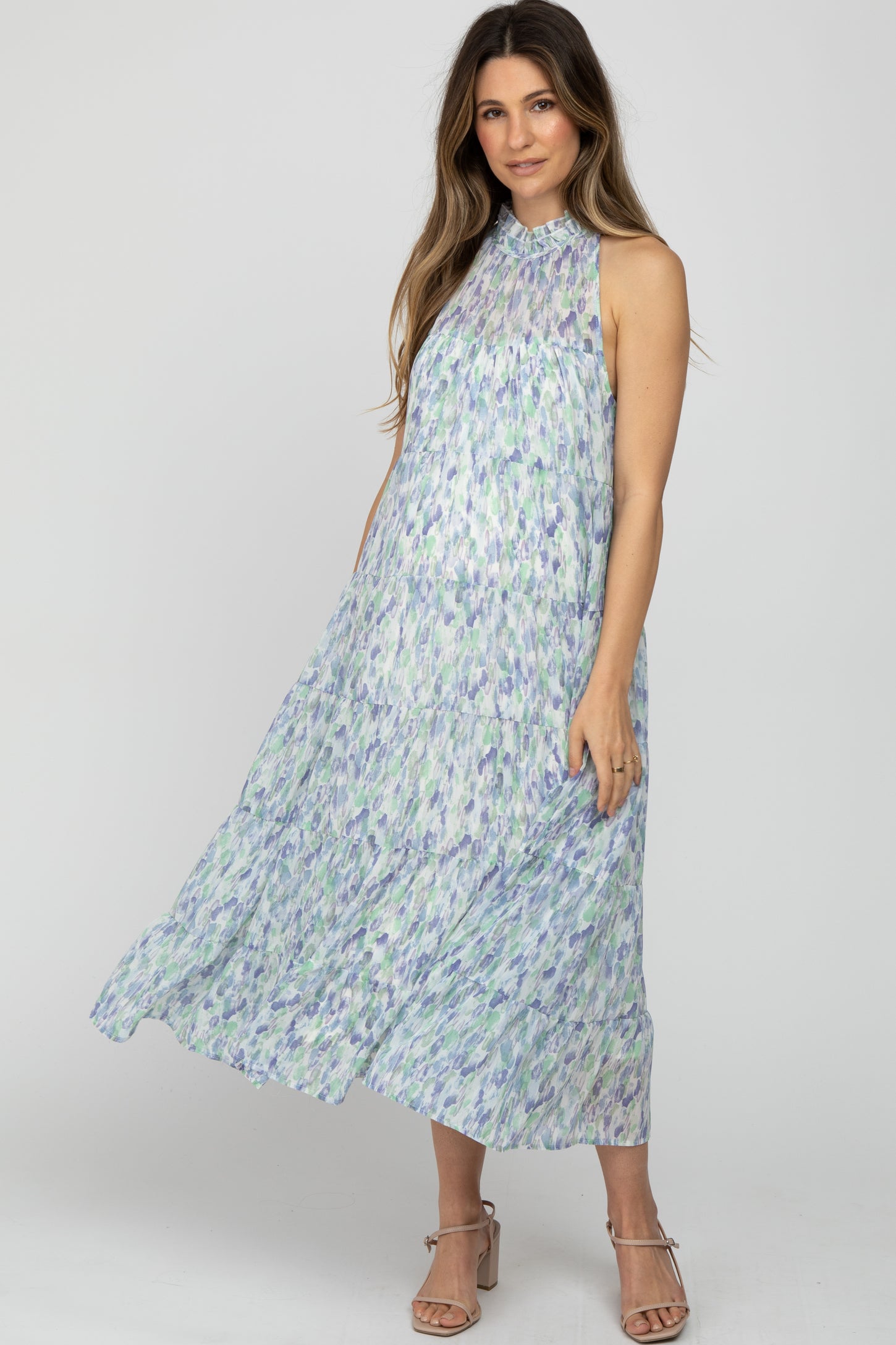woman wearing a floral patterned maternity maxi dress with a high neckline and flowy tiers