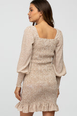 woman wearing a beige maternity dress with puff sleeves and ruffle hem, showcasing a fitted silhouette