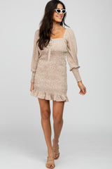 woman wearing a beige floral print mini dress with puff sleeves and a ruffled hem, styled with sunglasses and heels