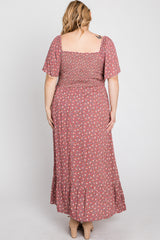 Back view of a woman in a plus size mauve floral maxi dress with smocked bodice and flutter sleeves