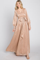 woman wearing a beige long sleeve wrap maxi dress with a tied waist and vertical stripes