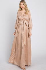 woman wearing a long sleeve champagne colored maxi dress with a tie waist and vertical ribbed texture