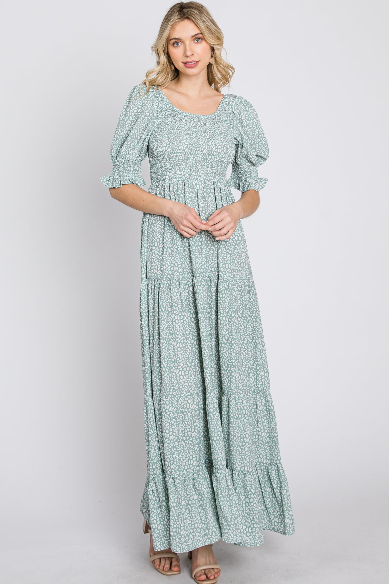 woman wearing a sage green floral smocked maxi dress with puff sleeves and tiered skirt