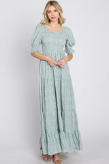 woman wearing a sage green floral smocked maxi dress with puff sleeves and tiered skirt
