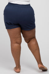 Rear view of person wearing navy blue elastic waist shorts with crochet trim hem and tan sandals