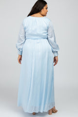 Back view of a woman wearing a light blue long sleeve striped maxi dress with a cinched waist