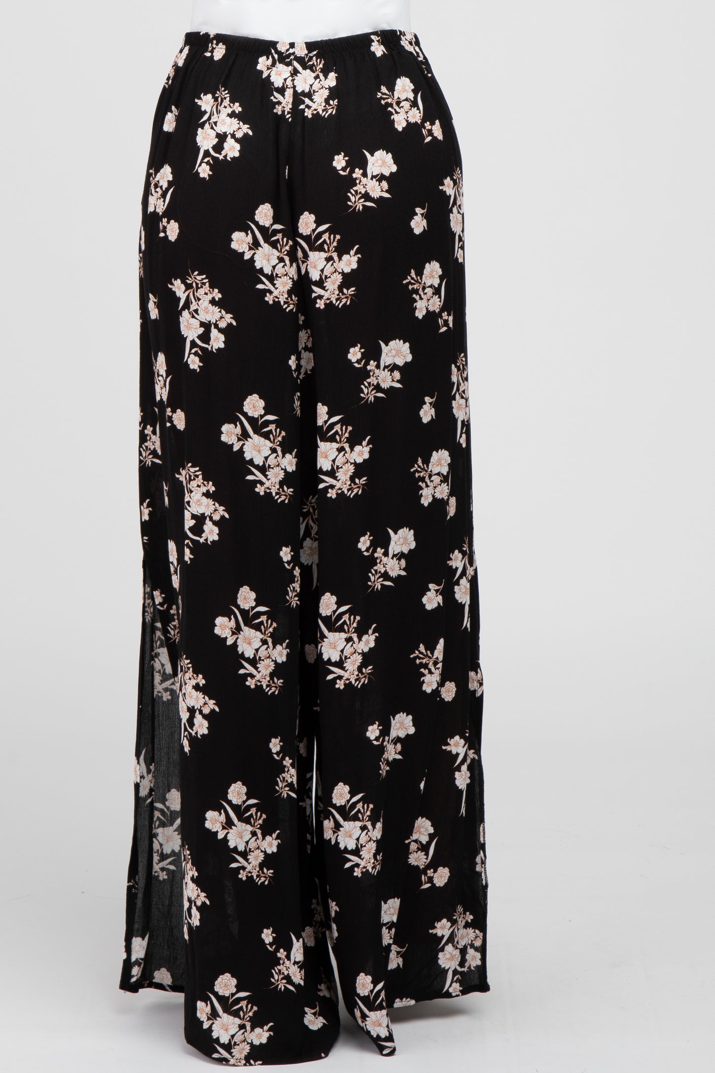 black wide leg pants with white floral print and side slits on a white background