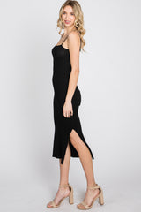 woman wearing a black ribbed midi dress with side slits and beige block heel sandals