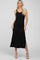 blonde woman wearing a sleeveless black midi dress with side slits and beige heels