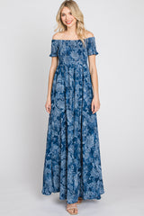 Woman wearing a blue off-the-shoulder floral maxi dress with a smocked bodice and short sleeves
