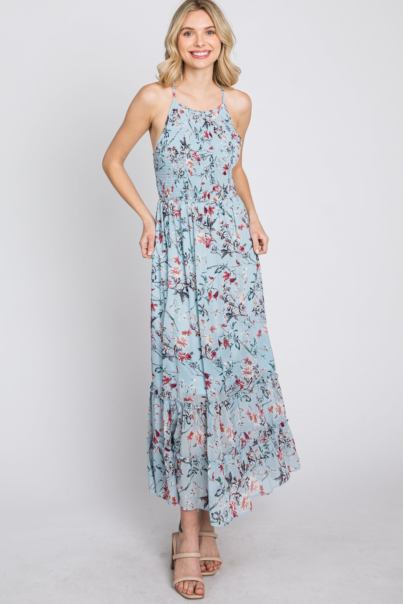 woman wearing light blue floral halter neck maxi dress with smocked bodice and tiered skirt