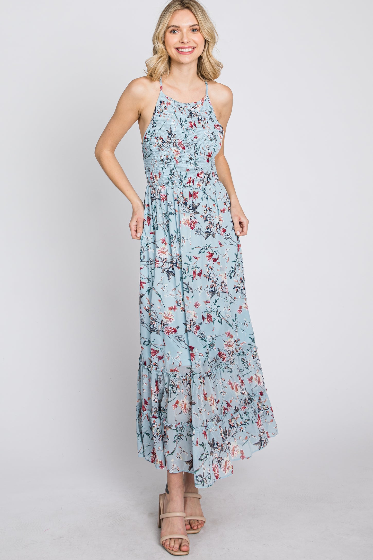 woman wearing light blue floral halter neck maxi dress with smocked bodice and tiered skirt