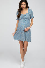 pregnant woman in blue floral maternity mini dress with puff sleeves and white sneakers