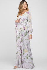Pregnant woman wearing a light purple floral long sleeve maternity maxi dress with a waist tie