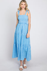 woman wearing a blue and white gingham tiered maxi dress with smocked bodice and tie straps